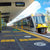 TacPro yellow polyurethane tactile warning and directional indicators on train station platform. Train sits at station