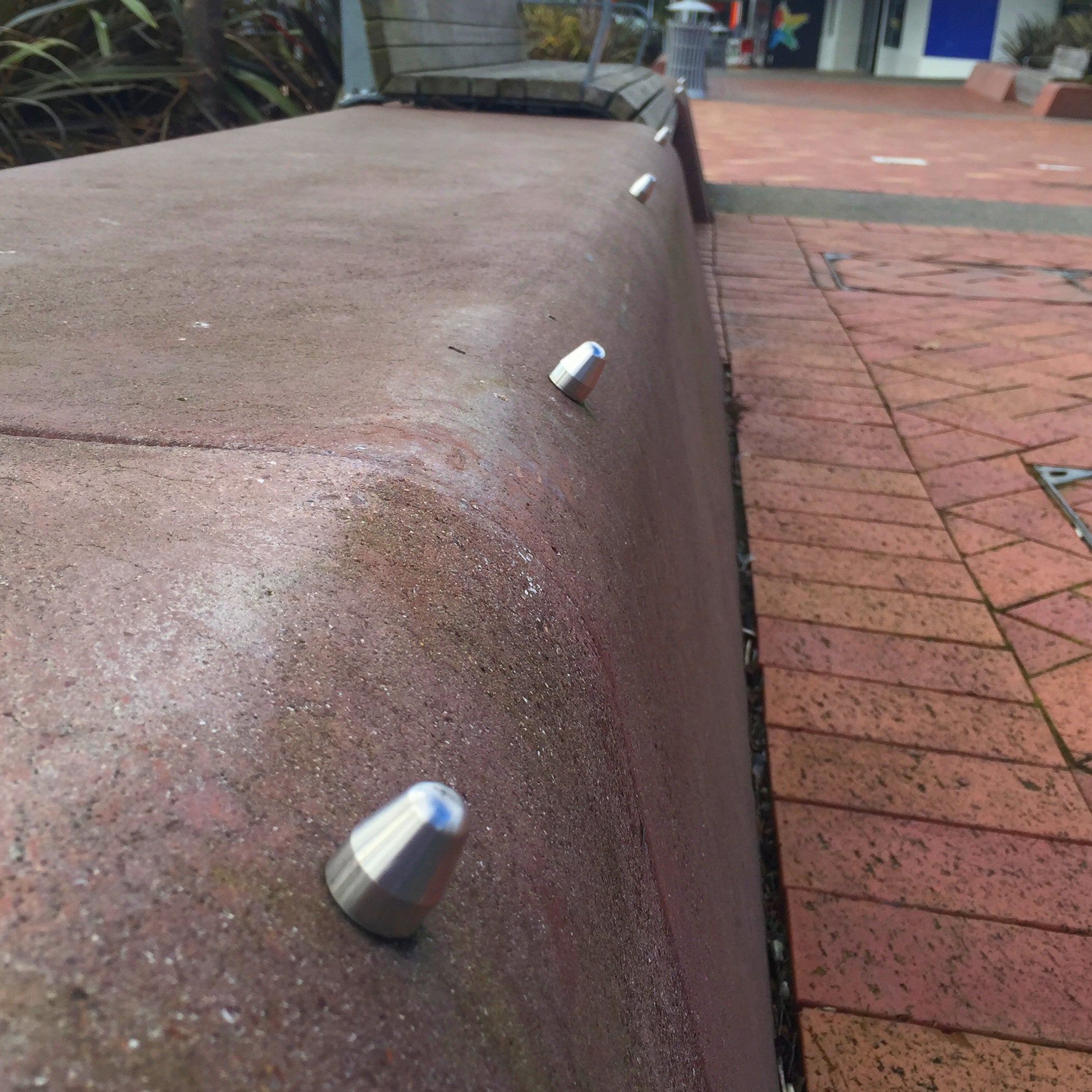 TacPro stainless steel skateboard deterrents (cone shape) installed on curved stone wall