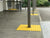 TacPro yellow peel-and-stick tactile indicator warning tiles on concrete surrounding support poles outside classrooms