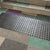 TacPro black peel-and-stick warning tactile tiles installed on multi-coloured carpet at the bottom of stairs at a school.